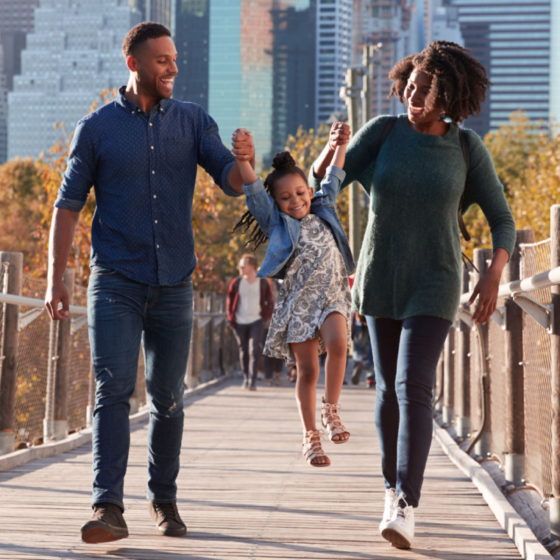 Young family with daughter taking a walk on footbridge