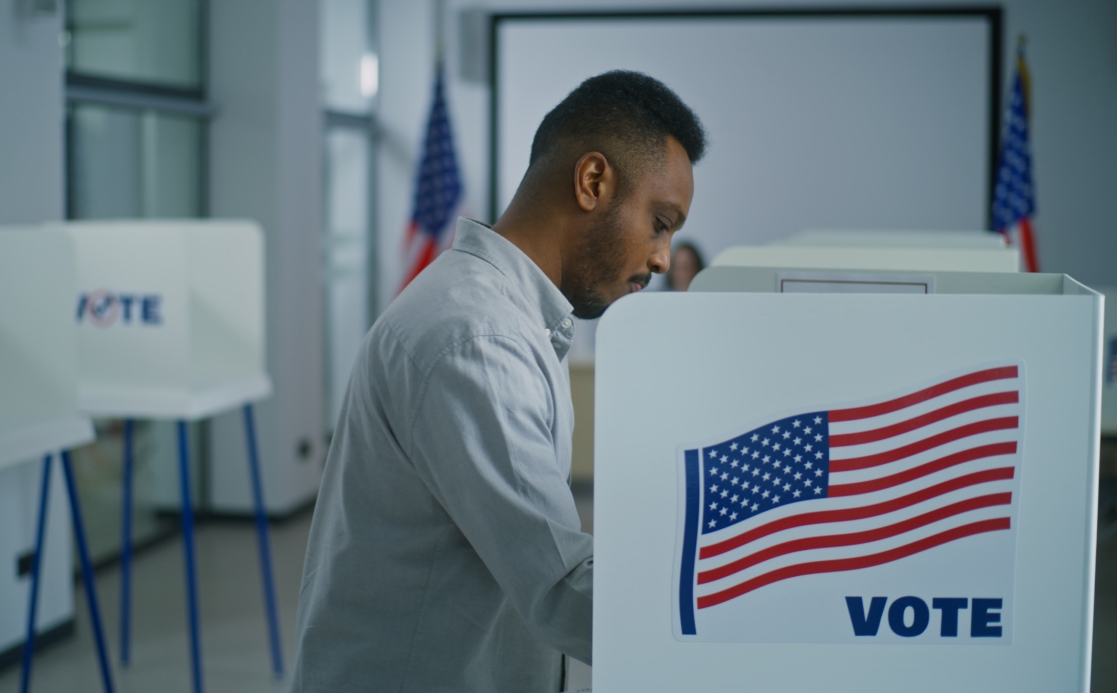 African American man takes paper ballot for voting
