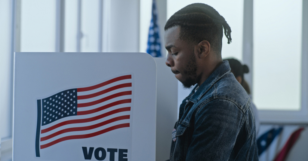 African American man stands and decides at voting booth